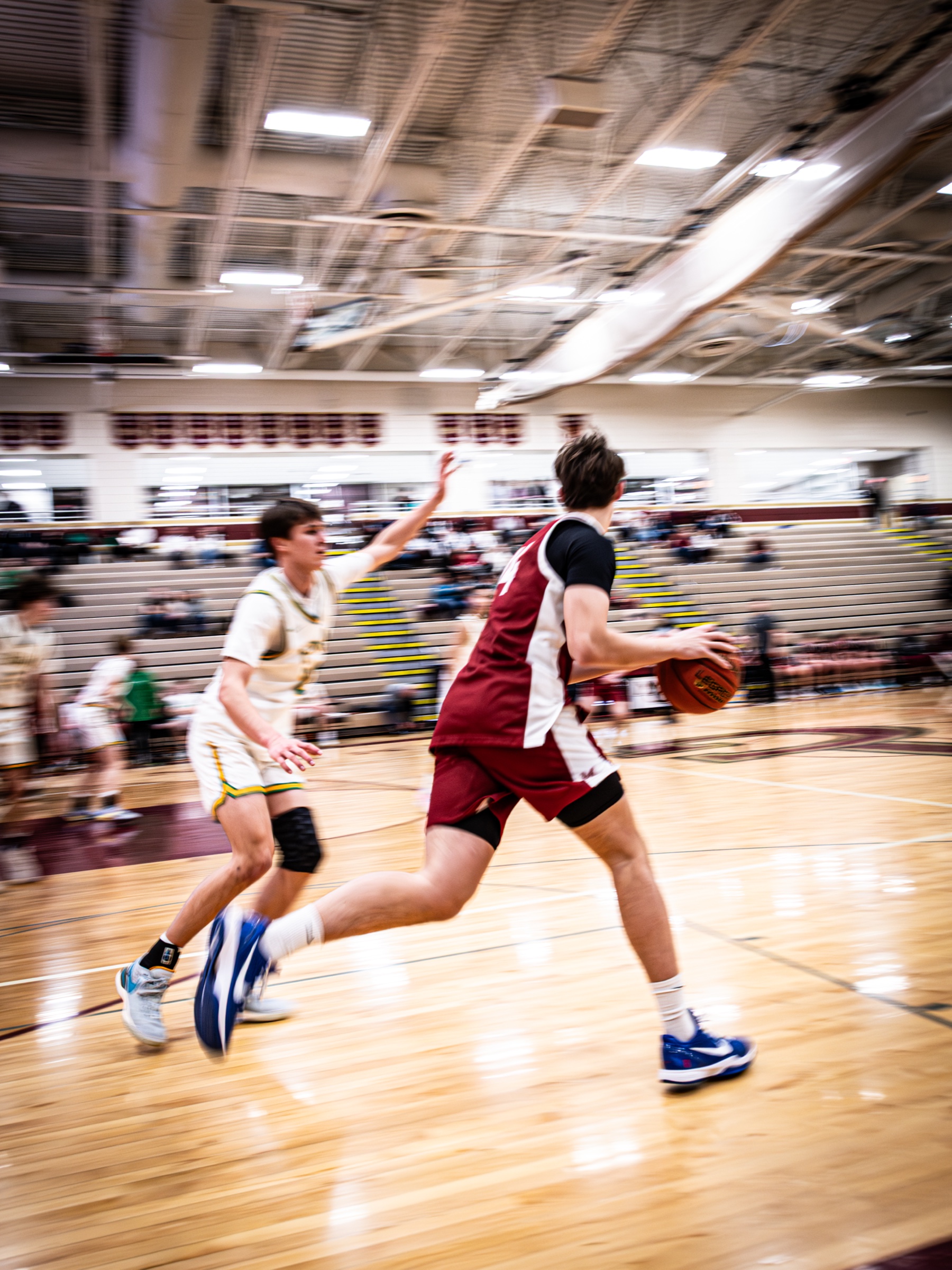 Basketball player driving downcourt during game coverage